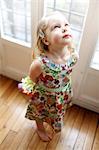 A 3 years old girl holding a flowers bouquet in her hands