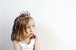 Portrait of a 3 years old girl pouting with a princess crown on the head