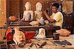 Camdodia, Siem Reap Province, Siem Reap Town, craft workshop, a sculptor works on an evea wood piece from Ratanakiri