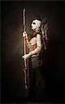 Tribal warrior standing in profile, with a spear