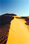 Morocco. Draa Valley. Tinfou. Tinfou dunes. Sunrise over the dunes. Tourist above the dune.