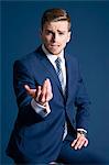 man in blue suit, glasses, blue background, cufflinks, watch