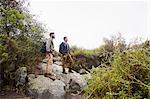 Two young men carrying backpacks hiking.