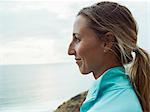 A smiling young woman, side profile, in a blue running top.