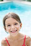 Little girl in swimming pool, smiling cheerfully, portrait