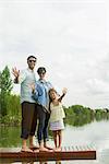 Family standing on dock waving