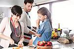 Family preparing food together in kitchen