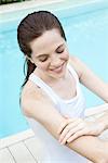 Young woman applying sunscreen