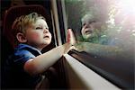 Baby boy gazing out train window in awe