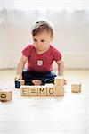 Baby boy playing with toy blocks arranged to read "E=mc2"