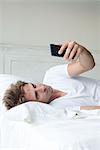 Man using smartphone on bed