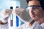 Scientist scrutinizing test tubes in lab