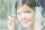 Woman preparing to write on window with marker