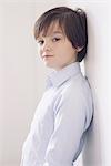 Boy leaning against wall, portrait