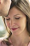 Man kissing woman's forehead, cropped