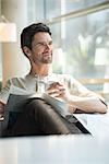 Man relaxing with coffee and newspaper