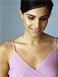 Woman in tank top smiling, looking down, portrait