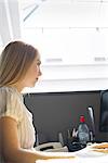 Young woman working intently in office cubicle