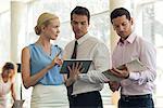 Businesswoman showing colleagues digital tablet