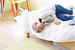 Boy lying on bed with stuffed toy