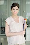 Woman carrying folders, smiling, portrait