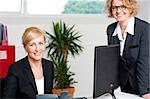 Joyful businesswomen enjoying at work desk