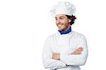 Chef standing with arms crossed, looking away