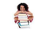 Smiling girl resting her arms on pile of books