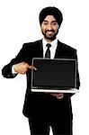 Indian salesman presenting brand new laptop