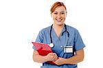 Smiling female physician posing with clipboard