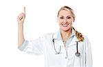 Attractive female doctor pointing finger upwards