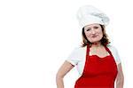 Mature female chef wearing red apron and toque