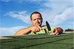 Man finishing installing the bitumen roof shingles - fastening the last pieces with nails and hammer