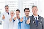 Portrait of confident doctors in row thumbs up in the hospital