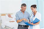 Doctor explaining report to female patient and husband in the hospital