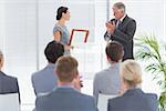Pretty businesswoman receiving prize in meeting room