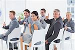 Smiling business team looking at camera during conference in meeting room