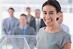 Smiling businesswoman looking at camera during conference in meeting room