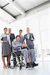 Disabled businessman with his colleagues smiling at camera in the office