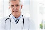 Confident male doctor looking at camera in medical office