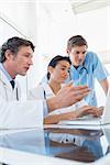 Team of doctors working on laptop computer in medical office