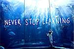 never stop learning against little boy looking at fish tank