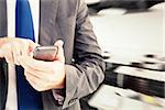 Businessman sending a text message against classroom