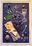Grape cheese wine chalk board. Delicious food ingredients for picnic. Vintage style. Toned photo.