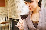 Young Japanese woman tasting wine in a fashionable bar
