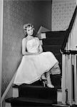 1950s 1960s WOMAN FORMAL COCKTAIL DRESS SITTING ON STAIRS LOOKING SAD WAITING FOR DATE STOOD UP