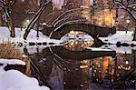 View across the Pond towards Gapstow Bridge in Central Park in Manhattan after a snow storm at dusk.