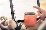 Hands of man using touchscreen on digital tablet at desk