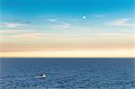 Fishing boat and full moon at dusk, Ponta do Criminoso, Buzios, Rio de Janeiro, Brazil