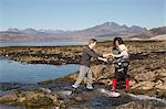 Mother holding son by Loch Eishort, Isle of Skye, Hebrides, Scotland